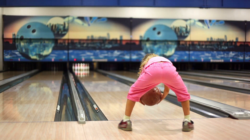 little-girl-in-pink-clothes-play-bowling-and-jumps_xyizddz9___F0000