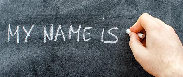 Teacher writing his name on blackboard